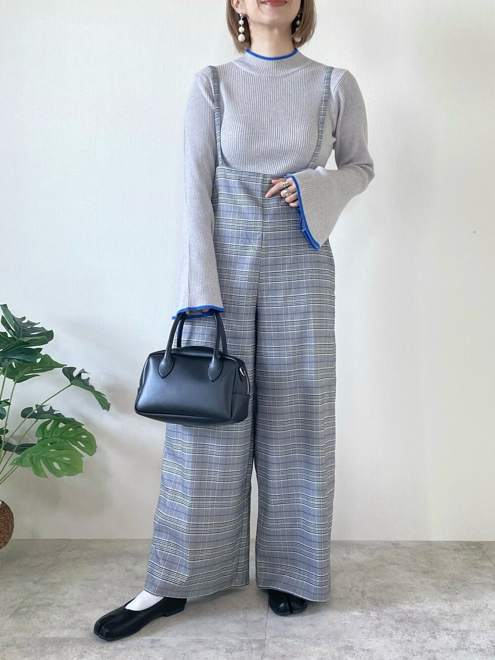 グレー系のニット/セーター、その他のサロペット/オーバーオール、ブラック系のバッグを着用したレディースの冬コーディネートの5枚目の写真