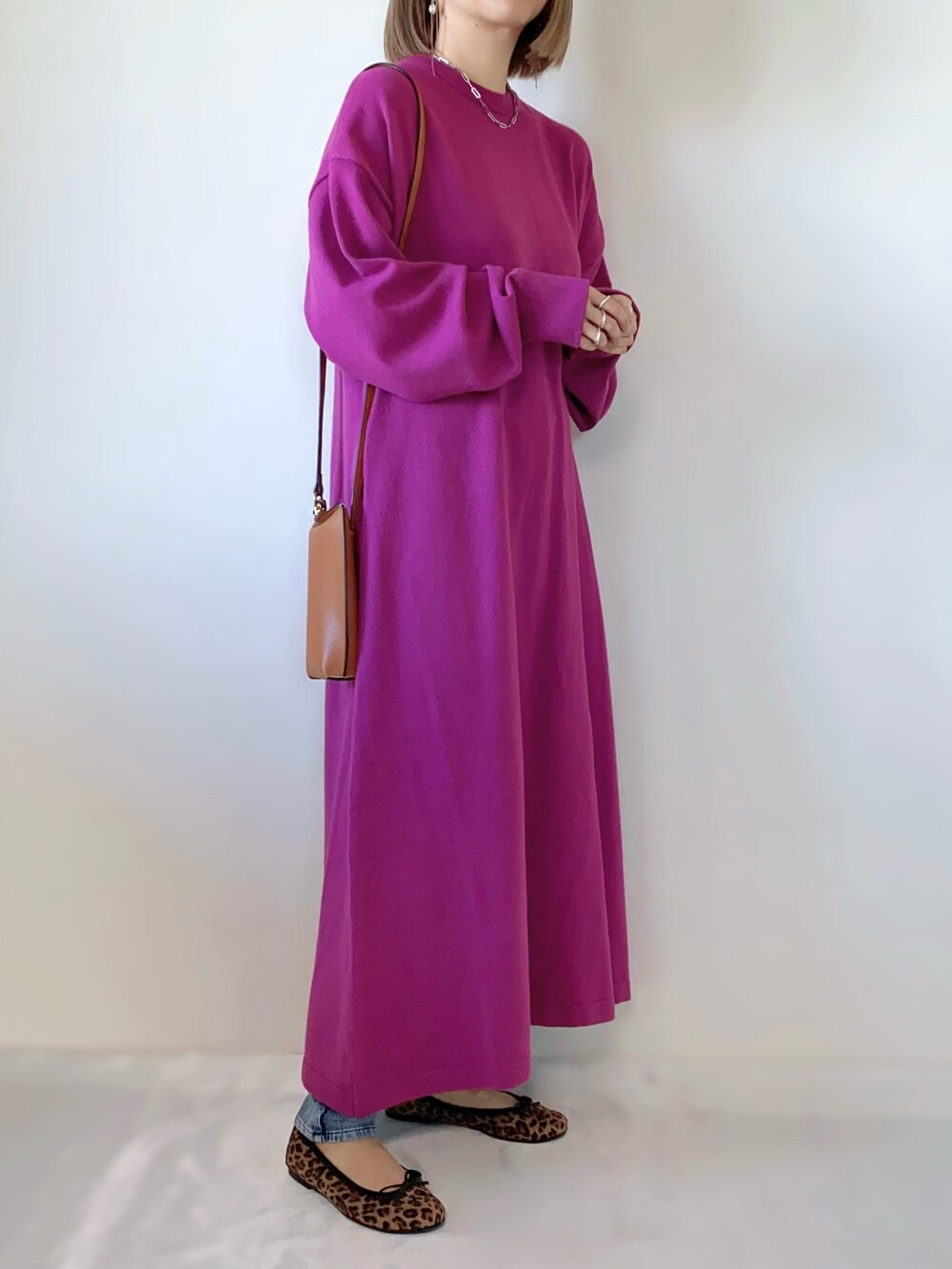 ピンク系のワンピース、ブラウン系のショルダーバッグ、ブラウン系のバレエシューズを着用したレディースの冬コーディネートの2枚目の写真