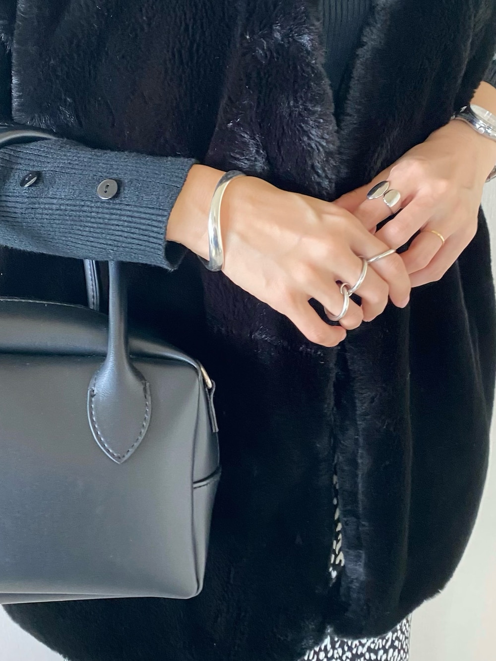 ブラック系のその他アウター、ブラック系のニット/セーター、ブラック系のバッグを着用したレディースの秋コーディネートの2枚目の写真