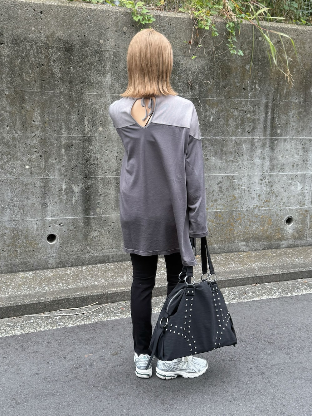 ブラック系のボストンバッグ、シルバー系のスニーカー、グレー系のTシャツ/カットソーを着用したレディースの秋コーディネートの2枚目の写真