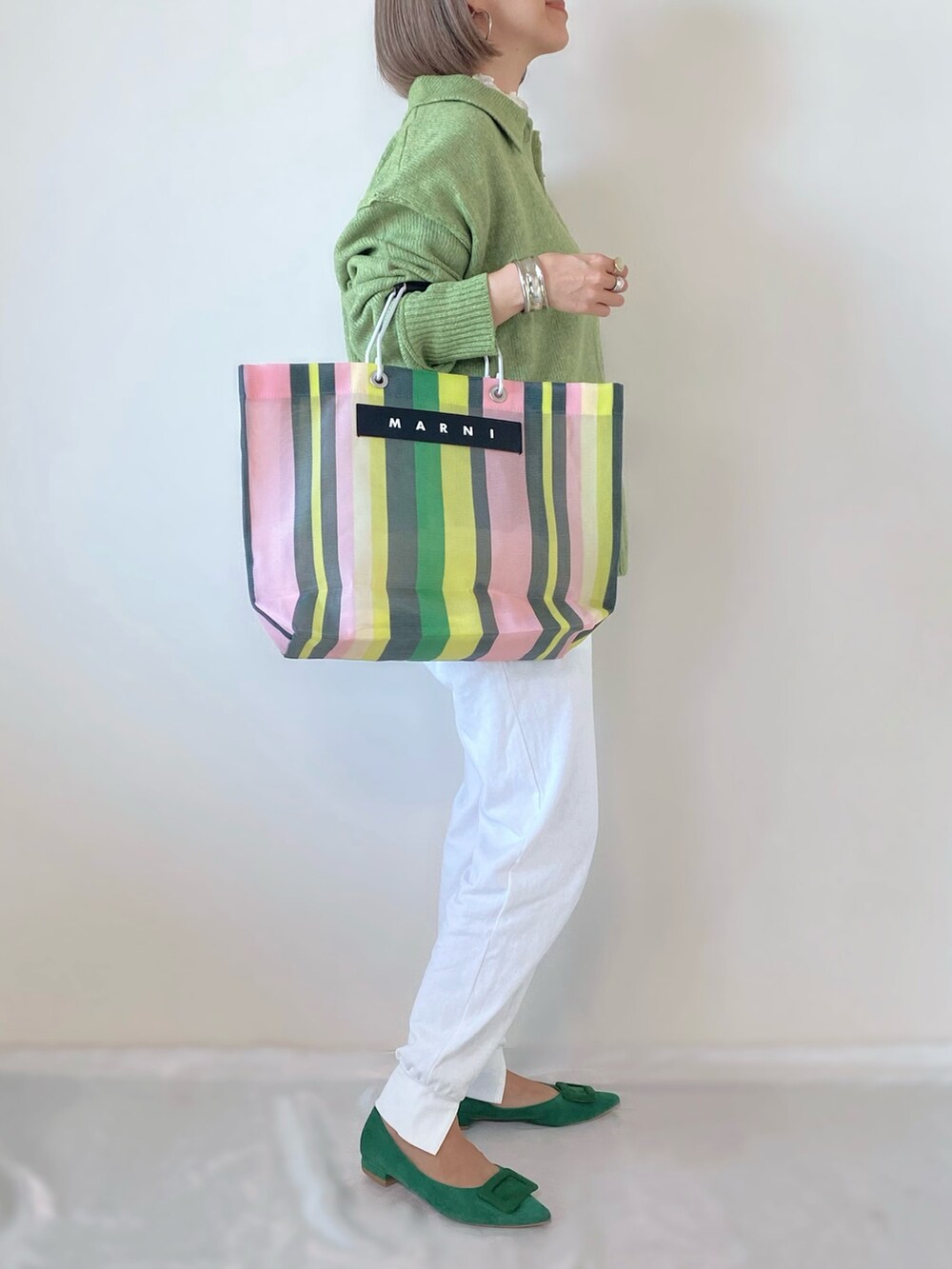 グリーン系のカーディガン/ボレロ、グリーン系のトートバッグ、ホワイト系のその他パンツを着用したレディースの秋コーディネートの2枚目の写真