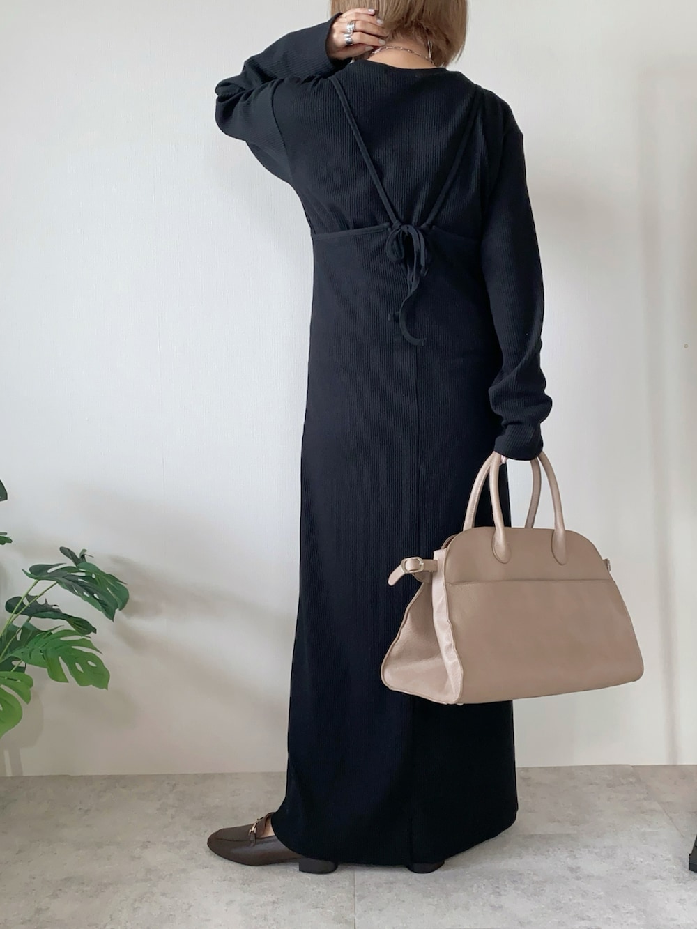 ブラック系のワンピース、ベージュ系のボストンバッグ、ブラウン系のローファーを着用したレディースの秋コーディネートの2枚目の写真