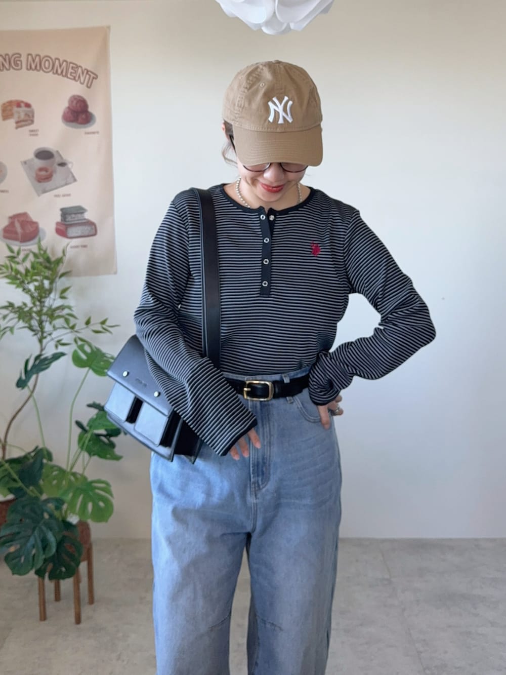 ブラック系のTシャツ/カットソー、ブラック系のショルダーバッグ、ブラック系のスニーカーを着用したレディースの冬コーディネートの4枚目の写真