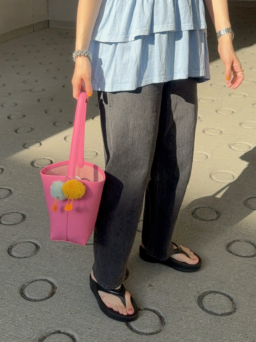 ブルー系のTシャツ/カットソー、ブラック系のデニムパンツ、ピンク系のショルダーバッグを着用したレディースの夏コーディネートの4枚目の写真