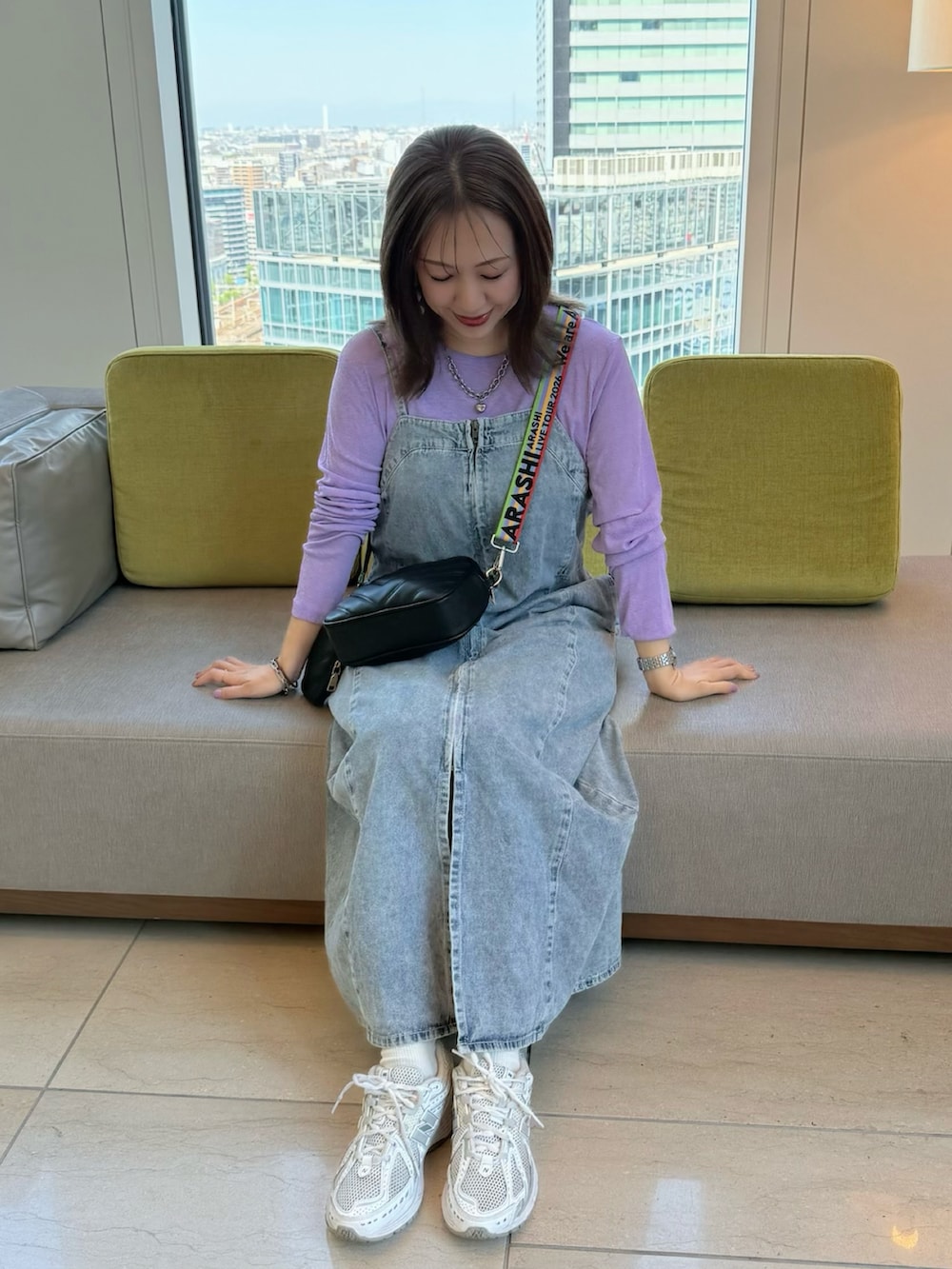 パープル系のTシャツ/カットソー、ブルー系のワンピース、ホワイト系のスニーカーを着用したレディースの春コーディネートの4枚目の写真