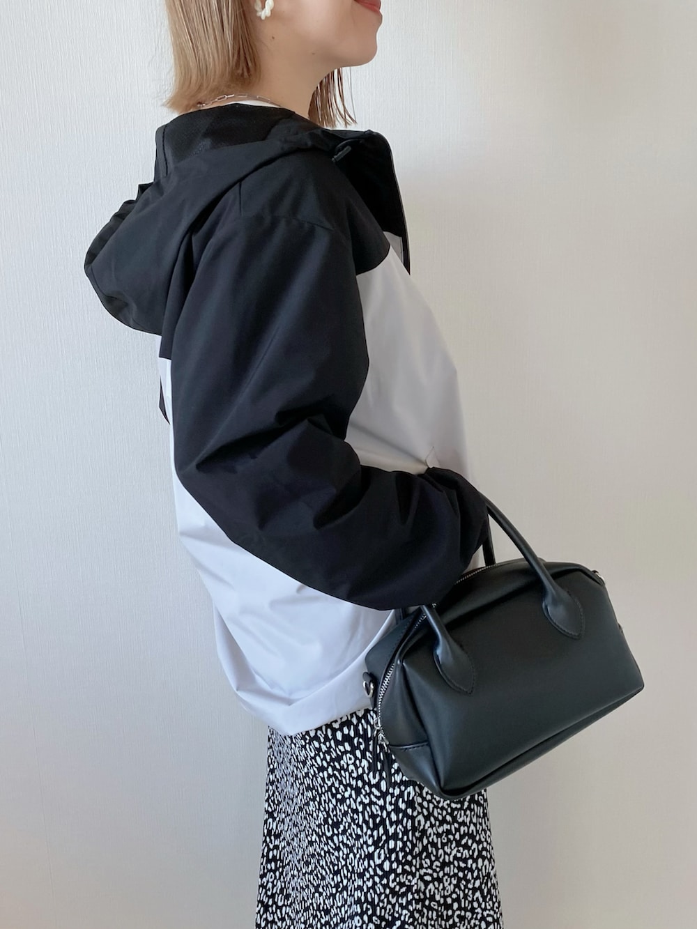 ブラック系のバッグ、ブラック系のスカート、ベージュ系のマウンテンパーカーを着用したレディースの春コーディネートの5枚目の写真