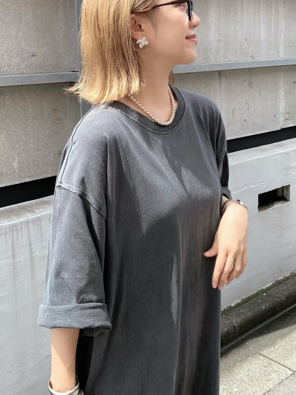 ピンク系のサンダル、ブラック系のバッグ、シルバー系のピアス（両耳用）を着用したレディースの夏コーディネートの4枚目の写真