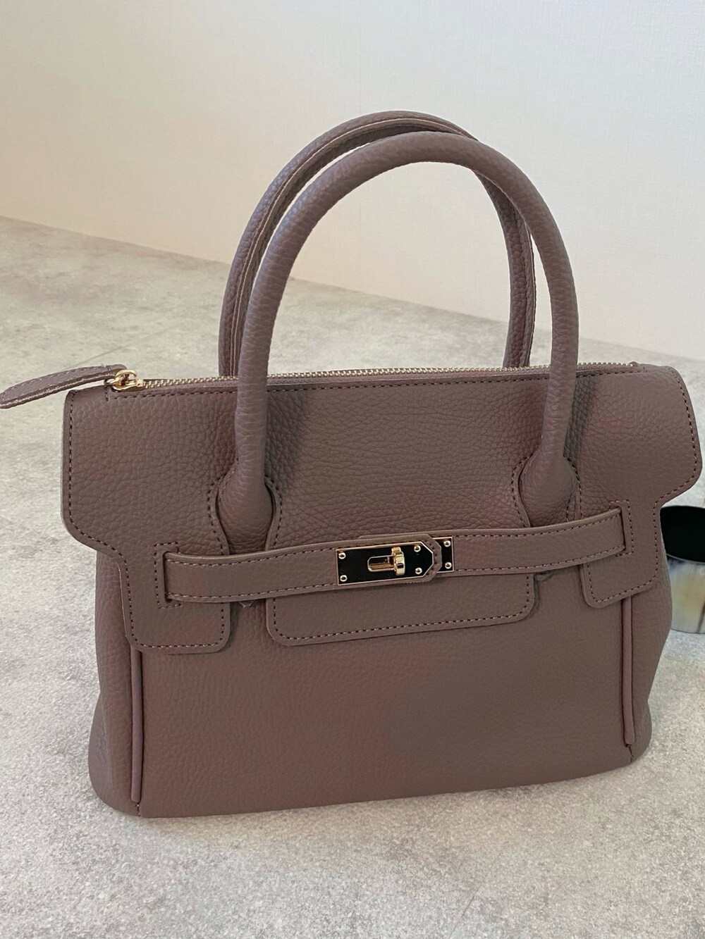 グレー系のニット/セーター、ゴールド系のネックレス、ブラック系のブレスレットを着用したレディースの秋コーディネートの4枚目の写真