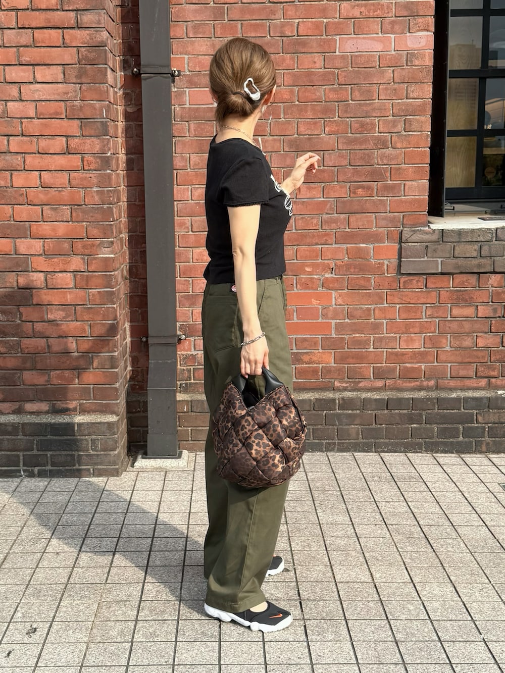 ブラック系のTシャツ/カットソー、グリーン系のチノパンツ、その他のショルダーバッグを着用したレディースの夏コーディネートの2枚目の写真