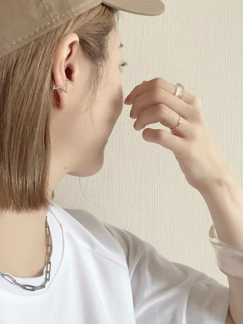 その他のイヤーカフ、イエロー系のキャップを着用したレディースの春コーディネートの4枚目の写真