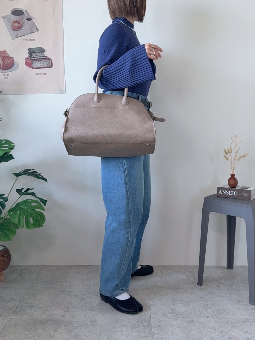 ブルー系のニット/セーター、ベージュ系のボストンバッグ、ブラック系のパンプスを着用したレディースの冬コーディネートの2枚目の写真