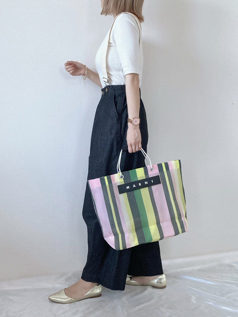 グリーン系のトートバッグ、ブラック系のデニムパンツ、ホワイト系のTシャツ/カットソーを着用したレディースの春コーディネートの4枚目の写真