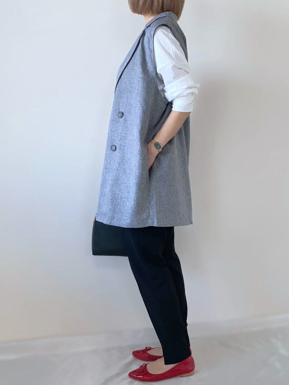 ホワイト系のTシャツ/カットソー、ブラック系のハンドバッグ、ブラック系のパンツを着用したレディースの春コーディネートの3枚目の写真