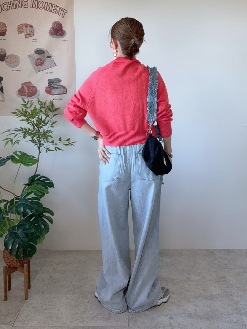 ブルー系のデニムパンツ、ブラック系のショルダーバッグ、グレー系のスニーカーを着用したレディースの春コーディネートの4枚目の写真