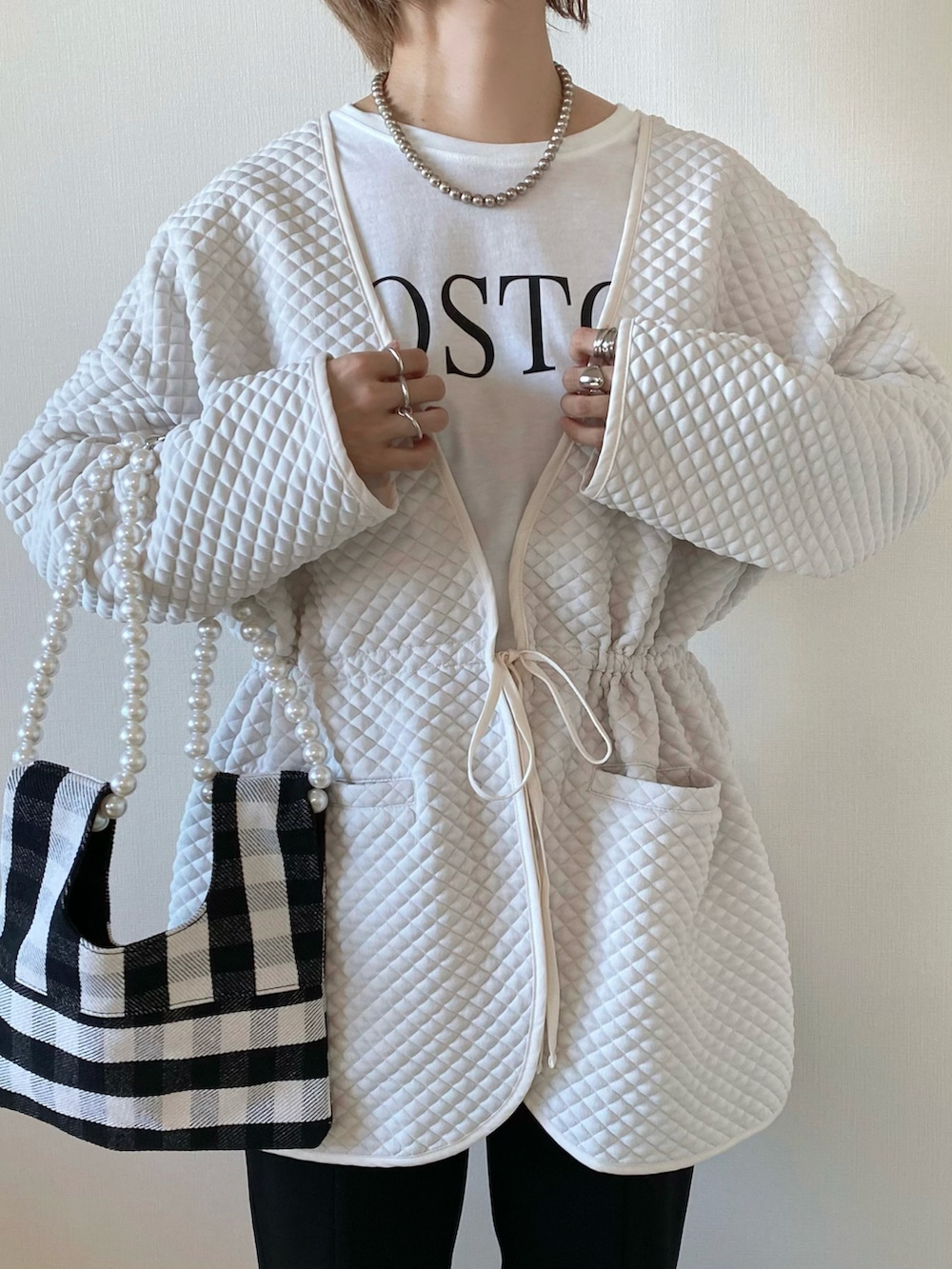 ホワイト系のTシャツ/カットソー、ブラック系のパンツ、ホワイト系のショルダーバッグを着用したレディースの秋コーディネートの5枚目の写真