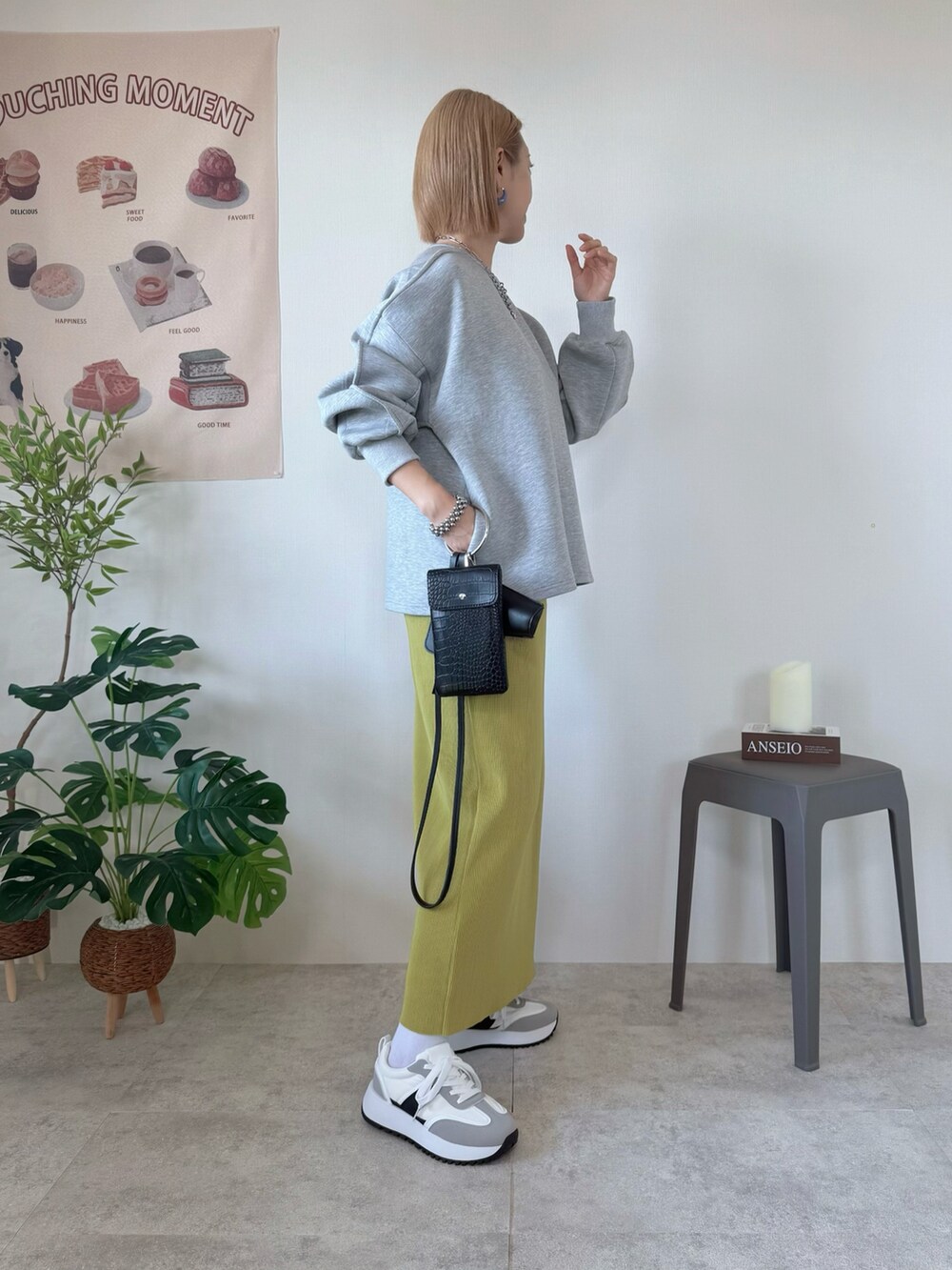 グリーン系のスカート、グレー系のスニーカー、グレー系のトップスを着用したレディースの春コーディネートの2枚目の写真