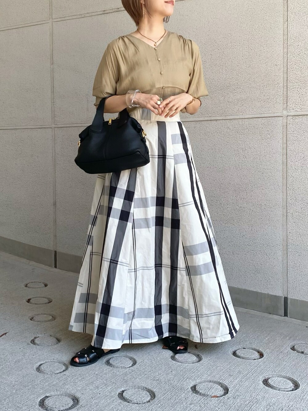 イエロー系のシャツ/ブラウス、ホワイト系のスカート、ブラック系のバッグを着用したレディースの夏コーディネートの4枚目の写真