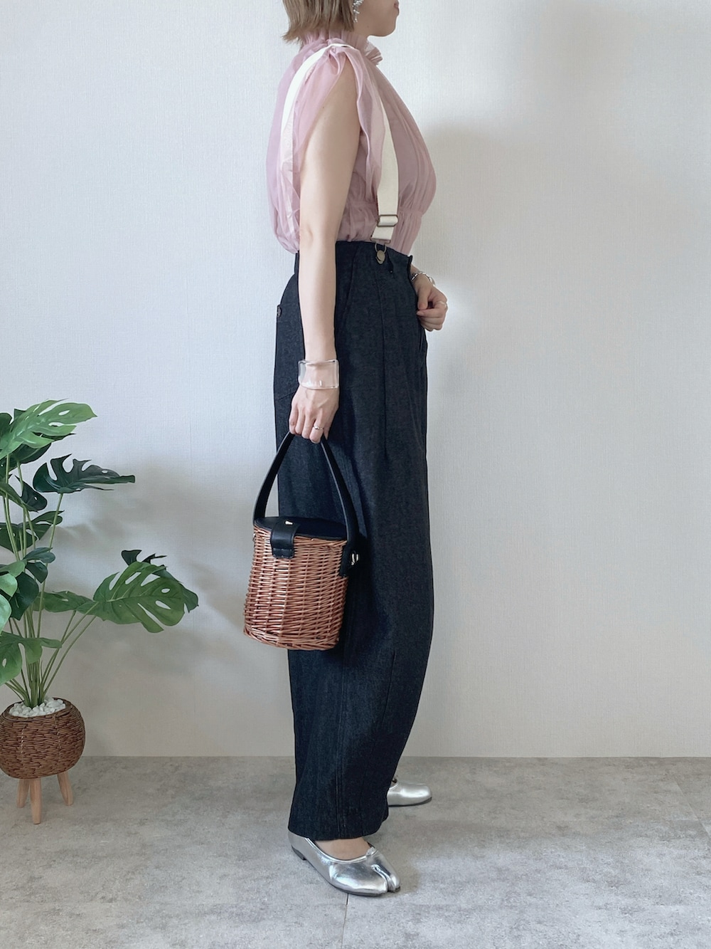 ピンク系のシャツ/ブラウス、ブラック系のバッグ、ブラック系のデニムパンツを着用したレディースの夏コーディネートの2枚目の写真