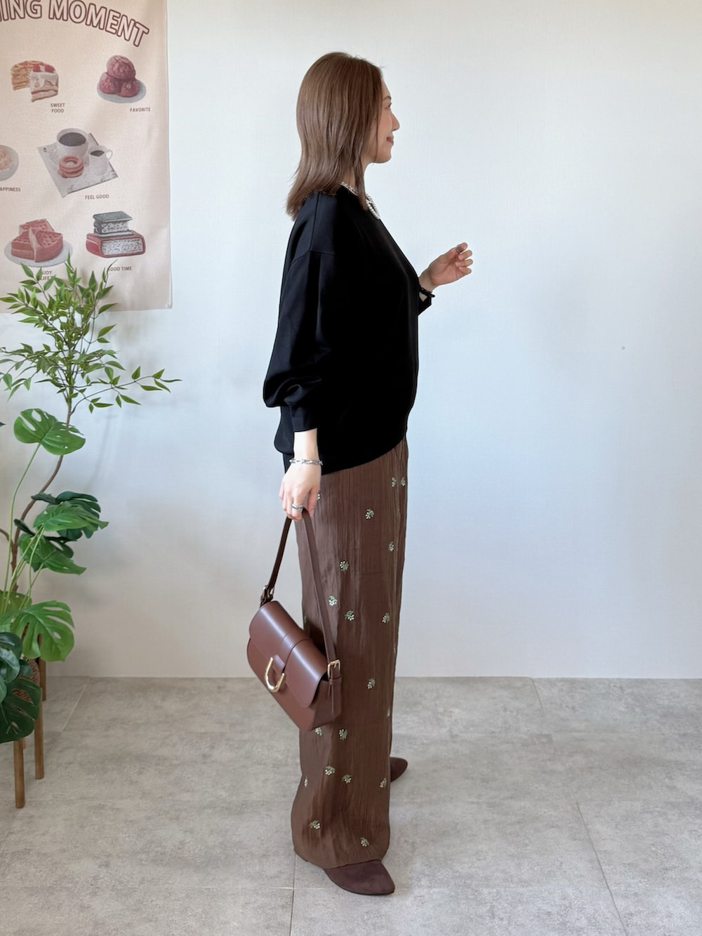 ブラック系のTシャツ/カットソー、ブラウン系のその他パンツ、ブラウン系のハンドバッグを着用したレディースの春コーディネートの2枚目の写真