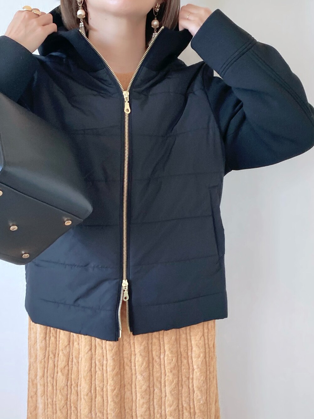 ブラック系のブルゾン、オレンジ系のワンピース、ブラック系のハンドバッグを着用したレディースの秋コーディネートの4枚目の写真