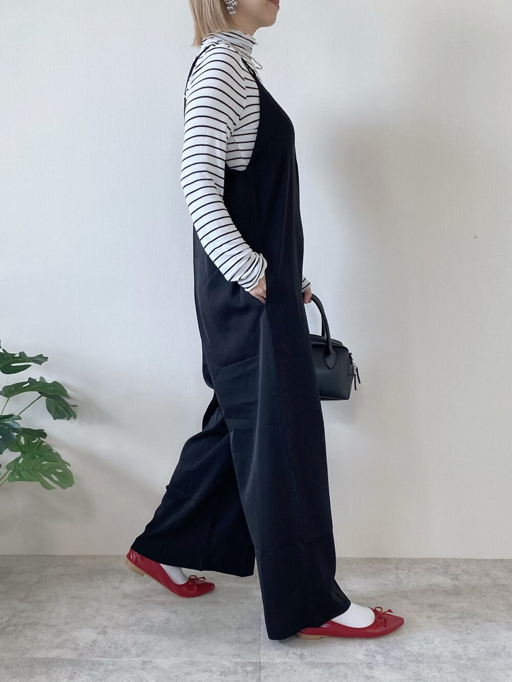 ブラック系のサロペット/オーバーオール、ホワイト系のTシャツ/カットソーを着用したレディースの冬コーディネートの3枚目の写真