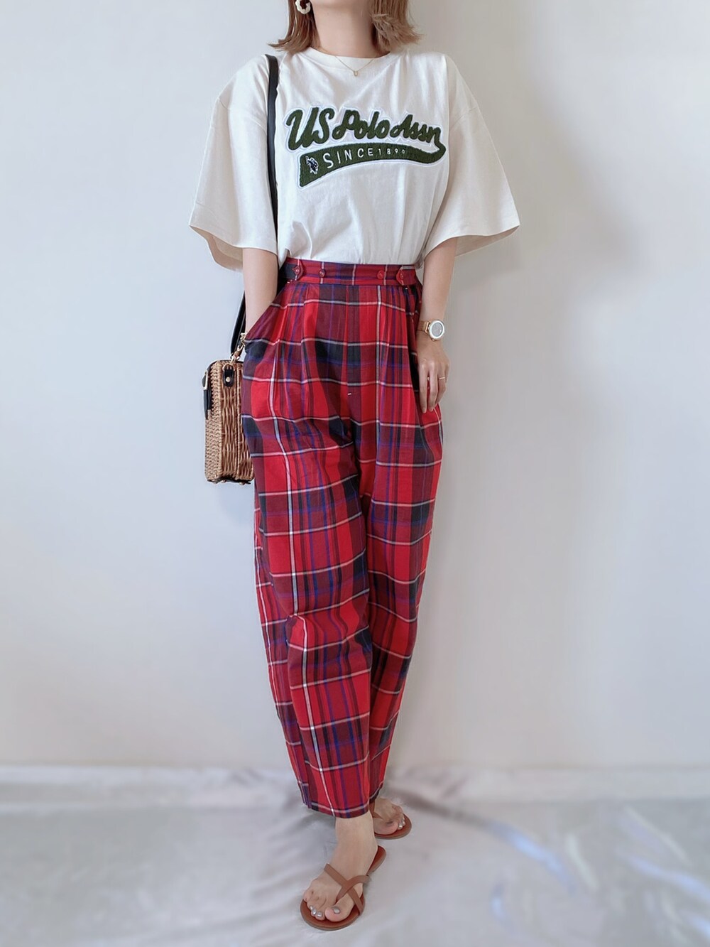 ベージュ系のTシャツ/カットソー、レッド系のパンツ、ブラウン系のショルダーバッグを着用したレディースの夏コーディネートの2枚目の写真