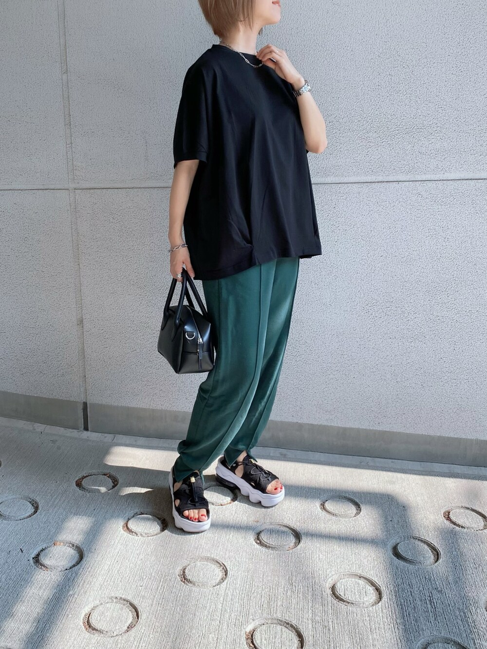 グリーン系のスウェットパンツ、ブラック系のTシャツ/カットソー、ブラック系のバッグを着用したレディースの夏コーディネートの4枚目の写真