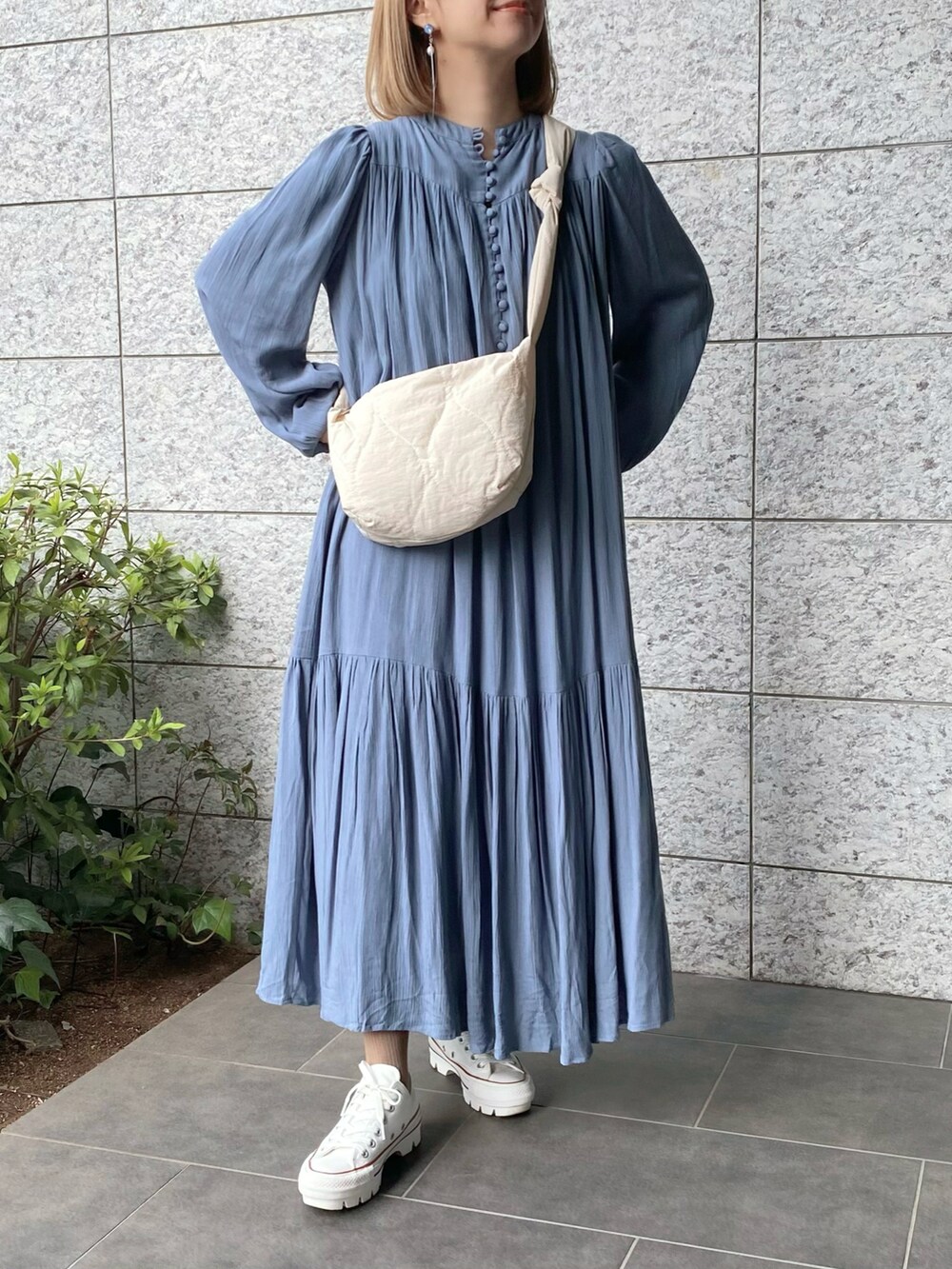 ホワイト系のショルダーバッグ、ブルー系のワンピース、ホワイト系のスニーカーを着用したレディースの春コーディネートの4枚目の写真