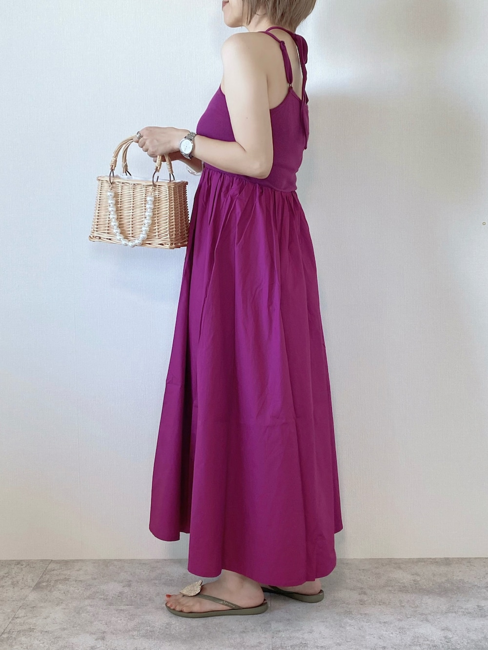 ピンク系のワンピース、ベージュ系のかごバッグ、ブルー系のベストを着用したレディースの夏コーディネートの4枚目の写真