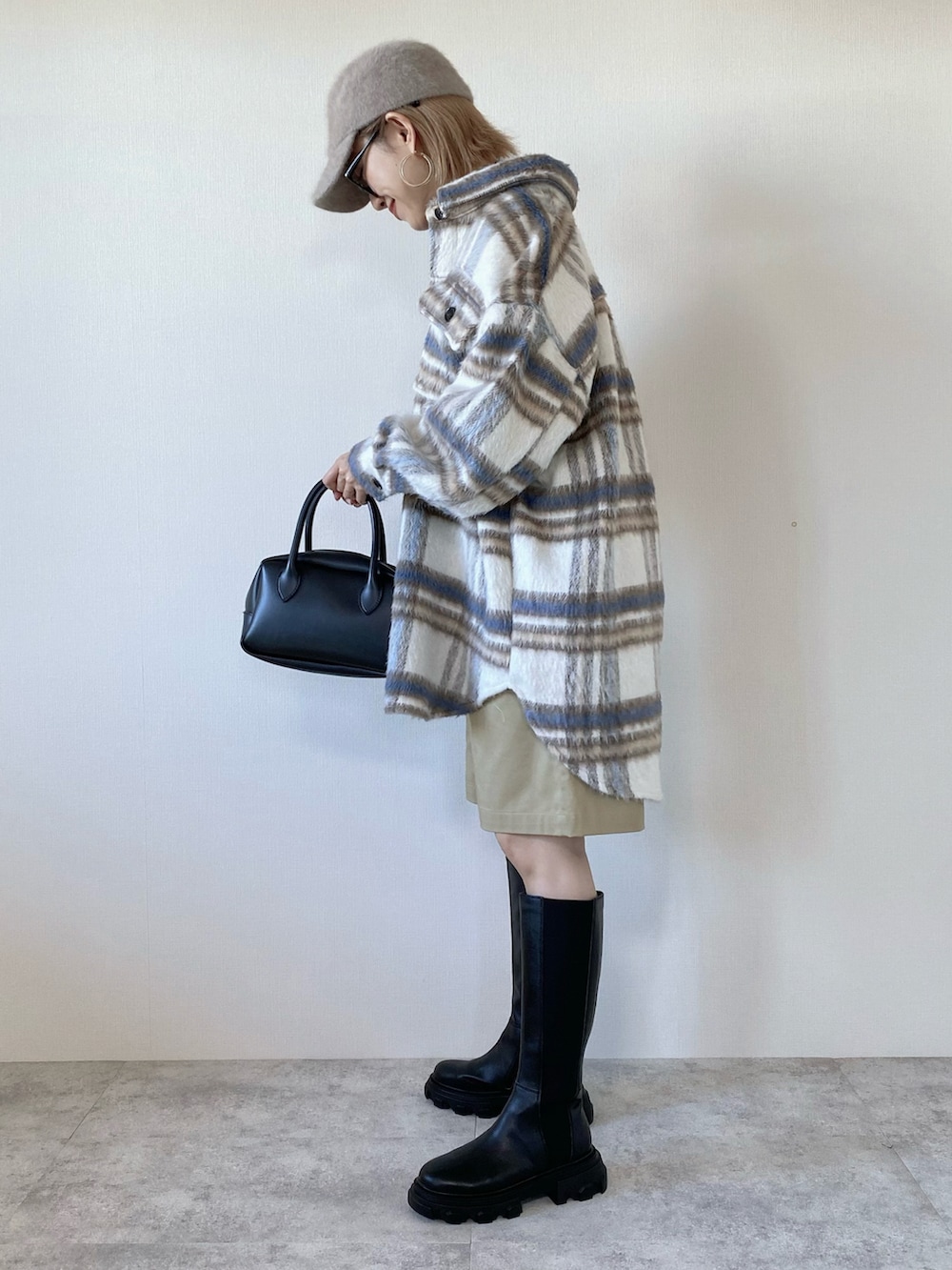 ホワイト系のブルゾン、ブラック系のニット/セーター、ブラック系のバッグを着用したレディースの秋コーディネートの3枚目の写真