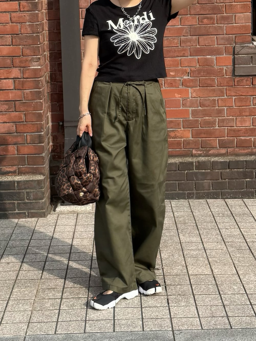 ブラック系のTシャツ/カットソー、グリーン系のチノパンツ、その他のショルダーバッグを着用したレディースの夏コーディネートの4枚目の写真