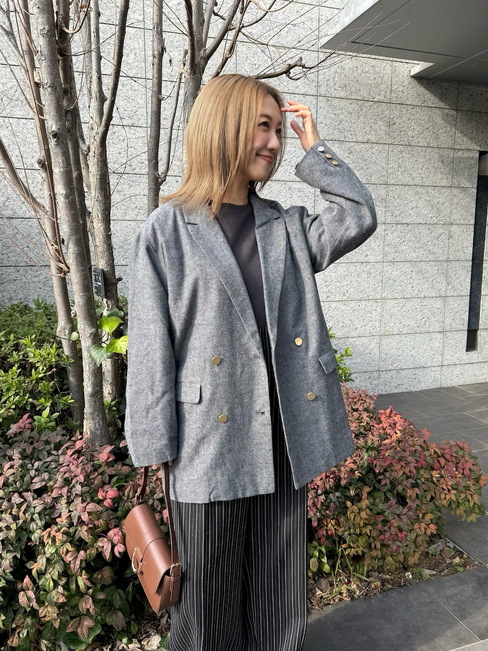 ブラック系のテーラードジャケット、ブラウン系のハンドバッグ、ブラック系のその他パンツを着用したレディースの冬コーディネートの4枚目の写真