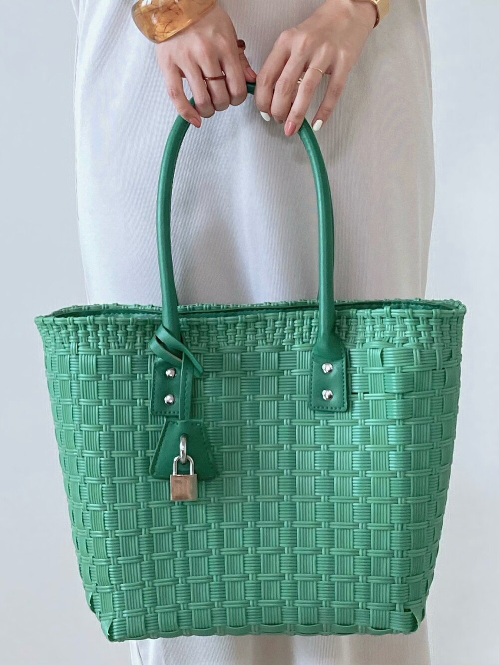 グリーン系のバッグ、ベージュ系のワンピースを着用したレディースの夏コーディネートの4枚目の写真