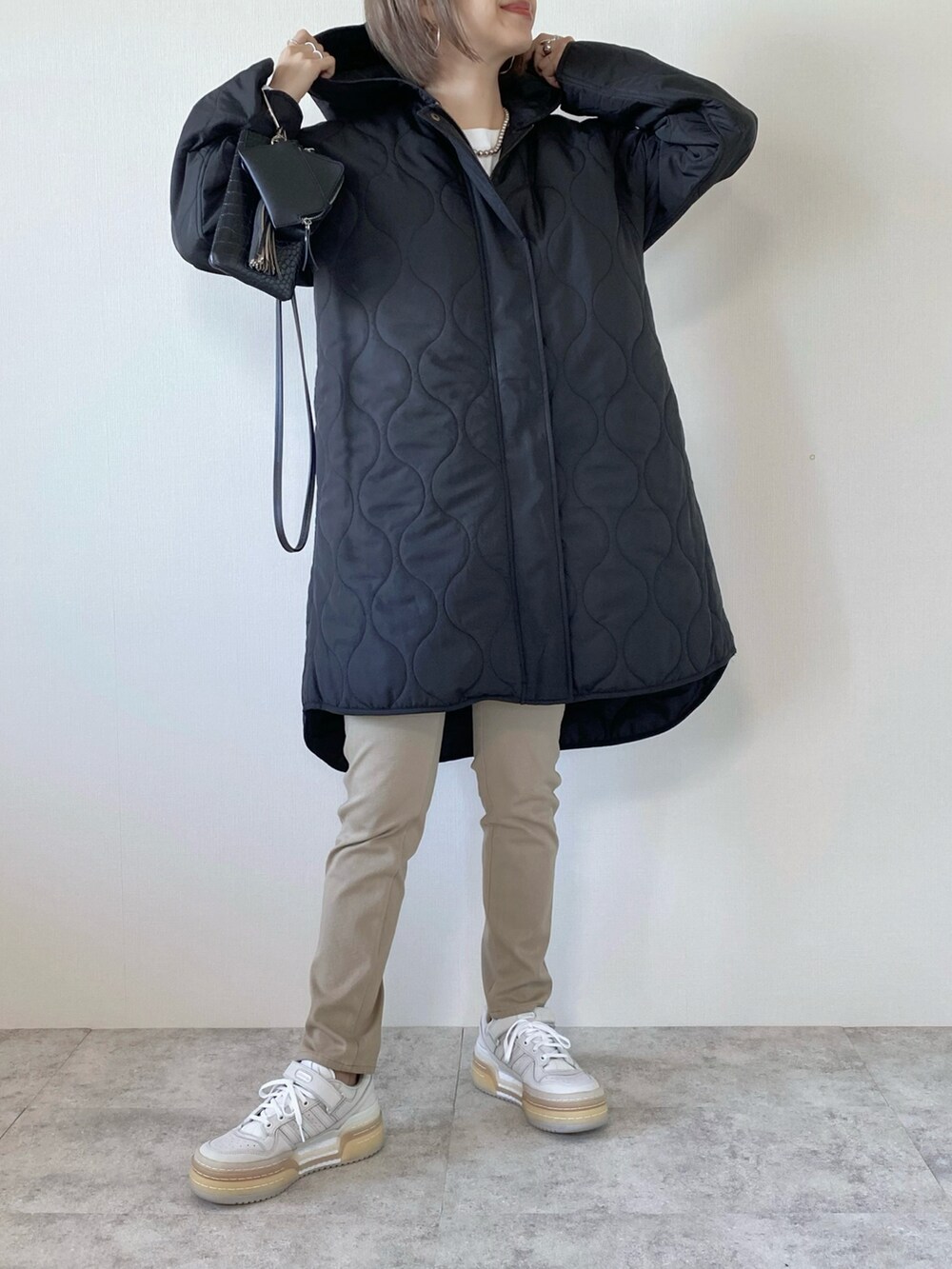 ホワイト系のスニーカー、ブラック系のショルダーバッグ、その他のTシャツ/カットソーを着用したレディースの秋コーディネートの2枚目の写真