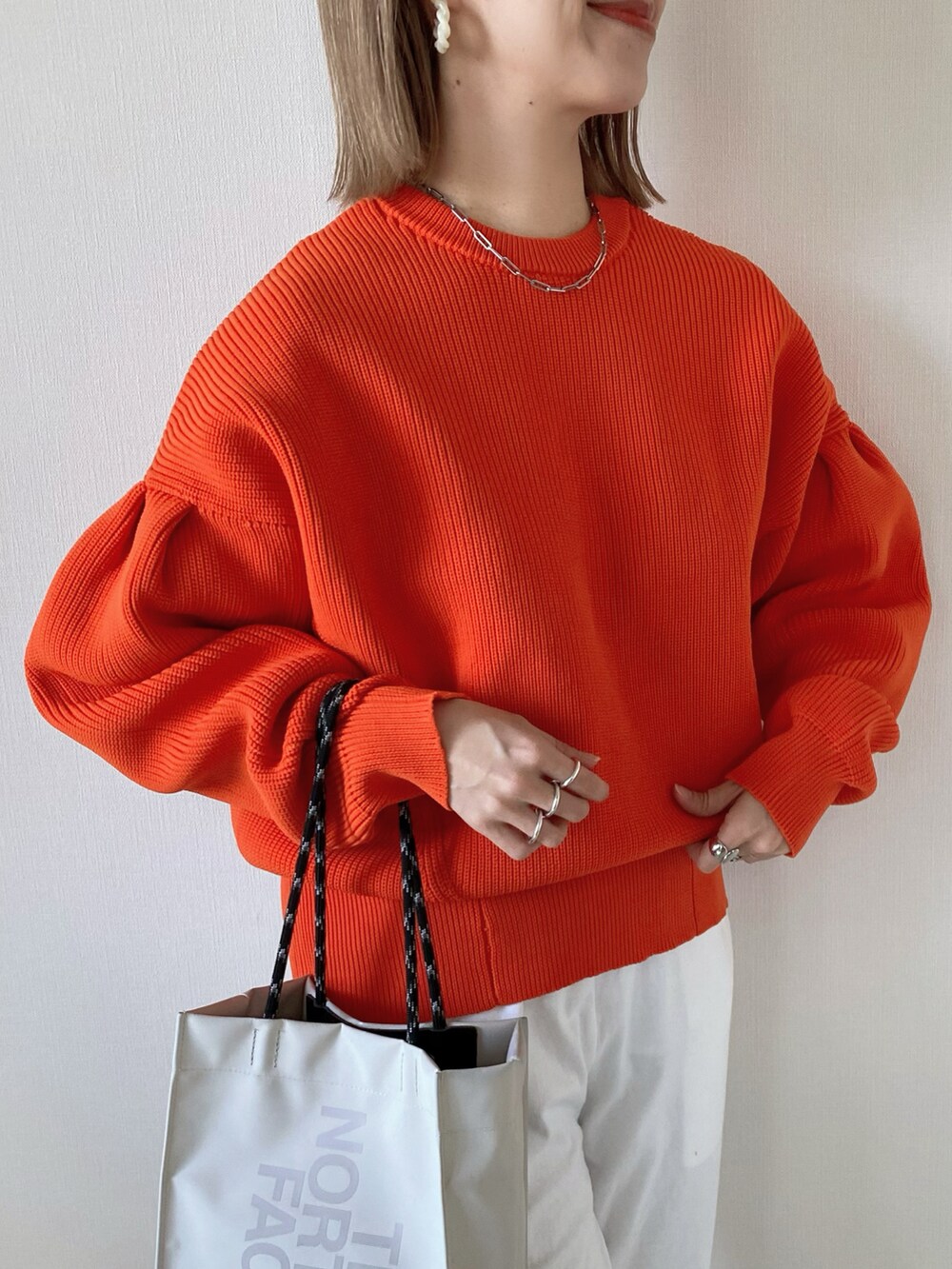 オレンジ系のカーディガン/ボレロ、ホワイト系のその他パンツ、ベージュ系のトートバッグを着用したレディースの春コーディネートの5枚目の写真