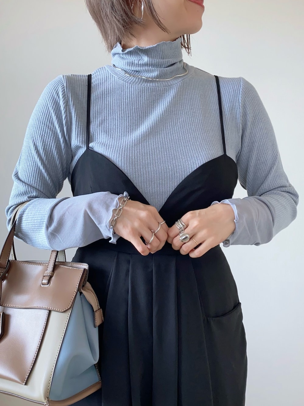 ブラック系のパンツドレス、その他のトートバッグを着用したレディースの秋コーディネートの2枚目の写真