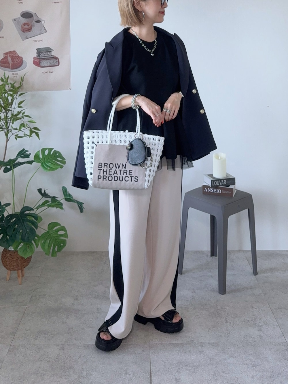 ブルー系のテーラードジャケット、ブラック系のスウェット、ホワイト系のかごバッグを着用したレディースの春コーディネートの3枚目の写真