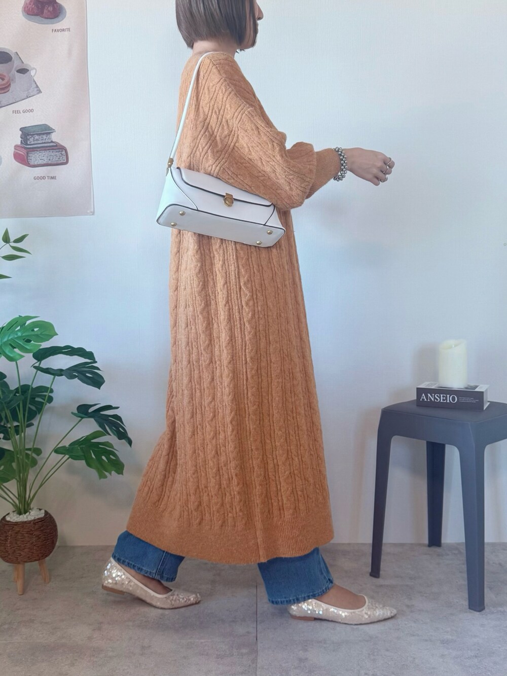 オレンジ系のワンピース、ホワイト系のハンドバッグ、ホワイト系のパンプスを着用したレディースの冬コーディネートの3枚目の写真