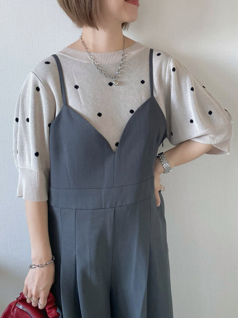 レッド系のボストンバッグ、グレー系のサロペット/オーバーオール、ベージュ系のニット/セーターを着用したレディースの夏コーディネートの4枚目の写真