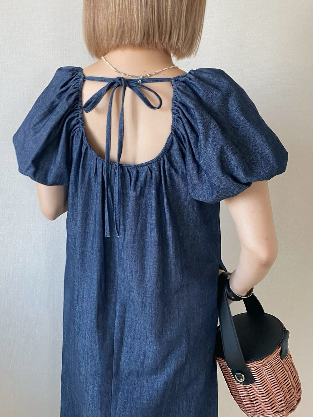 ブラック系のバッグ、ブルー系のワンピース、ブラック系のサンダルを着用したレディースの春コーディネートの5枚目の写真