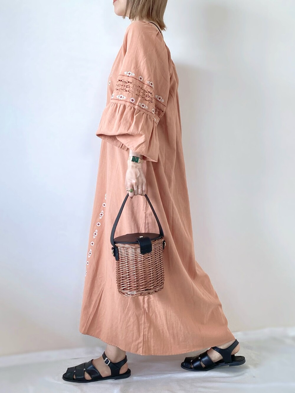 ブラック系のバッグ、ピンク系のワンピース、ブラック系のサンダルを着用したレディースの春コーディネートの2枚目の写真