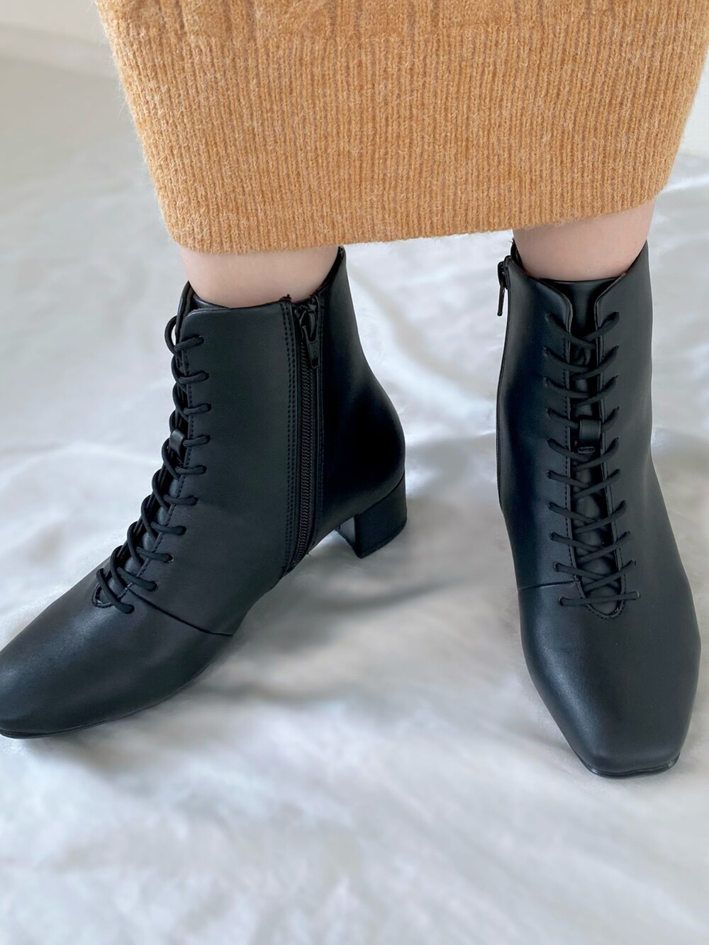 ブラック系のその他アウター、オレンジ系のワンピース、ブラック系のハンドバッグを着用したレディースの秋コーディネートの3枚目の写真