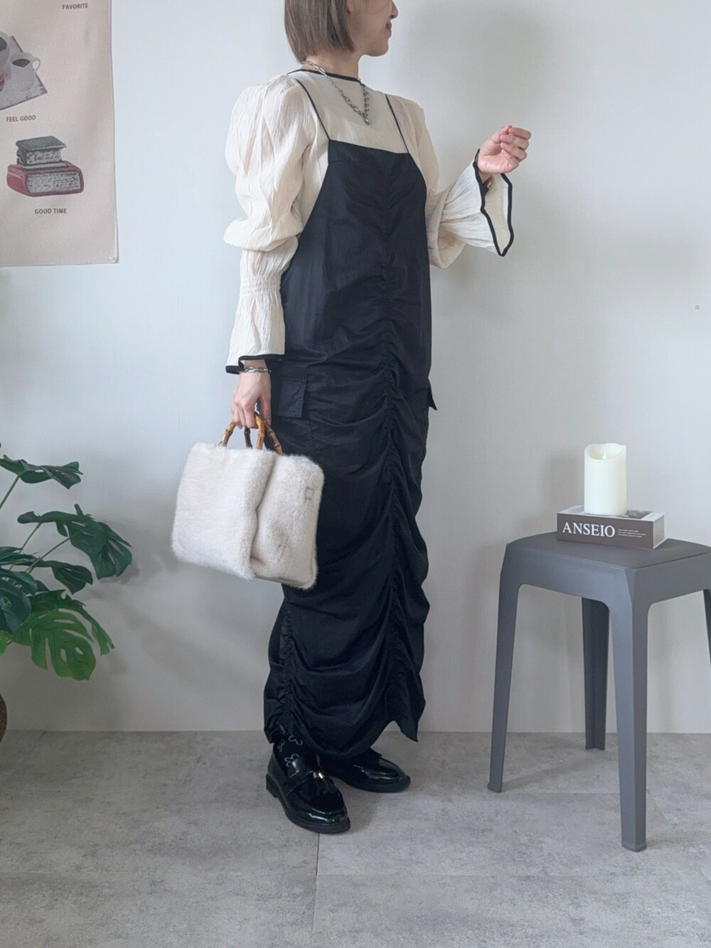 ブラック系のワンピース、ベージュ系のトートバッグ、ブラック系のローファーを着用したレディースの冬コーディネートの5枚目の写真