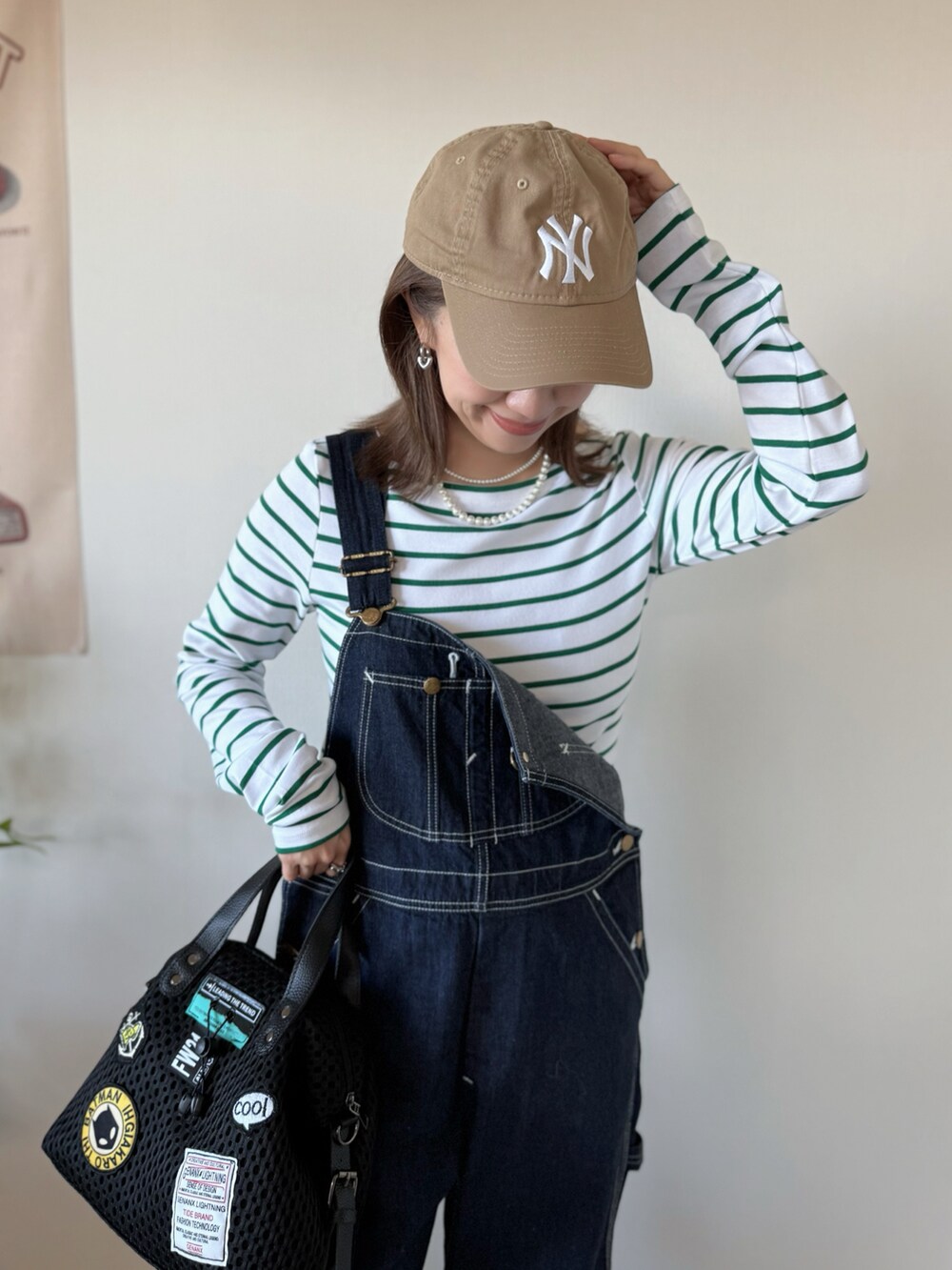 ホワイト系のスニーカー、ブラック系のボストンバッグ、グリーン系のTシャツ/カットソーを着用したレディースの冬コーディネートの5枚目の写真