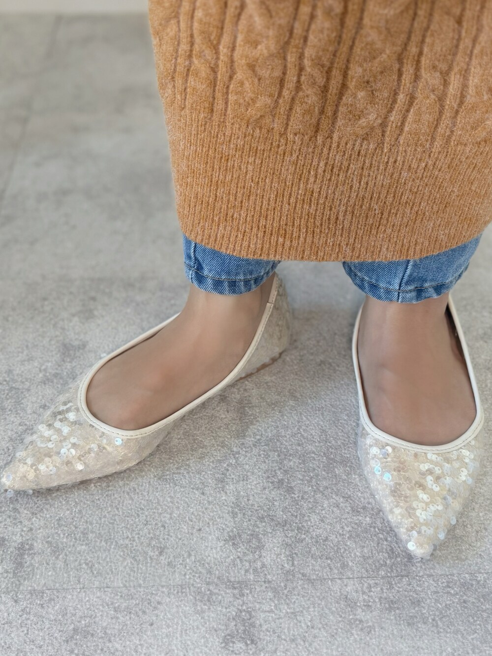 オレンジ系のワンピース、ホワイト系のハンドバッグ、ホワイト系のパンプスを着用したレディースの冬コーディネートの4枚目の写真