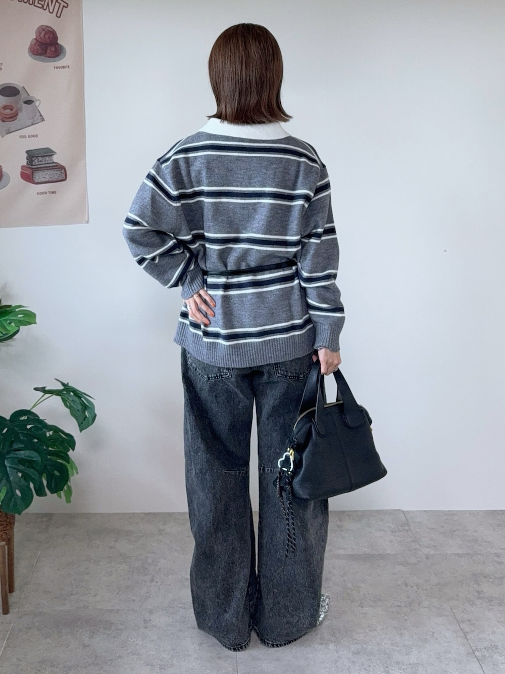 グレー系のニット/セーター、グレー系のデニムパンツ、ブラック系のベルトを着用したレディースの秋コーディネートの3枚目の写真