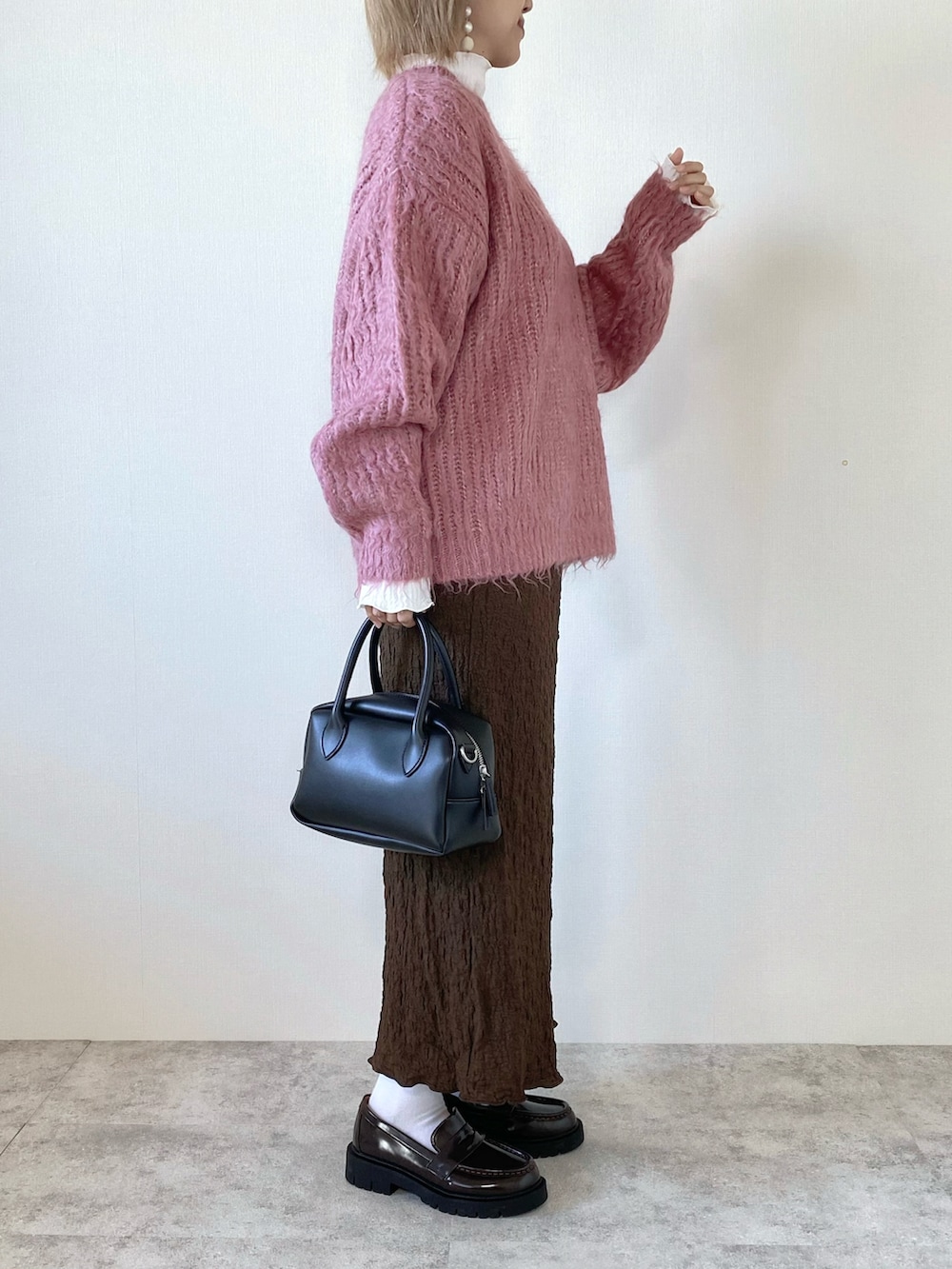 ブラウン系のスカート、ブラック系のバッグ、ホワイト系のTシャツ/カットソーを着用したレディースの秋コーディネートの2枚目の写真