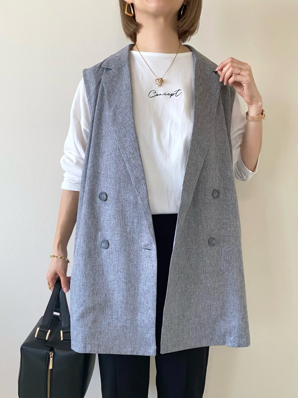 ホワイト系のTシャツ/カットソー、ブラック系のハンドバッグ、ブラック系のパンツを着用したレディースの春コーディネートの4枚目の写真