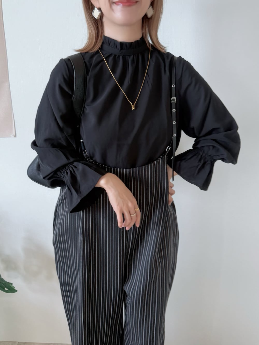 ブラック系のブーツ、ブラック系のシャツ/ブラウス、ブラック系のショルダーバッグを着用したレディースの秋コーディネートの4枚目の写真