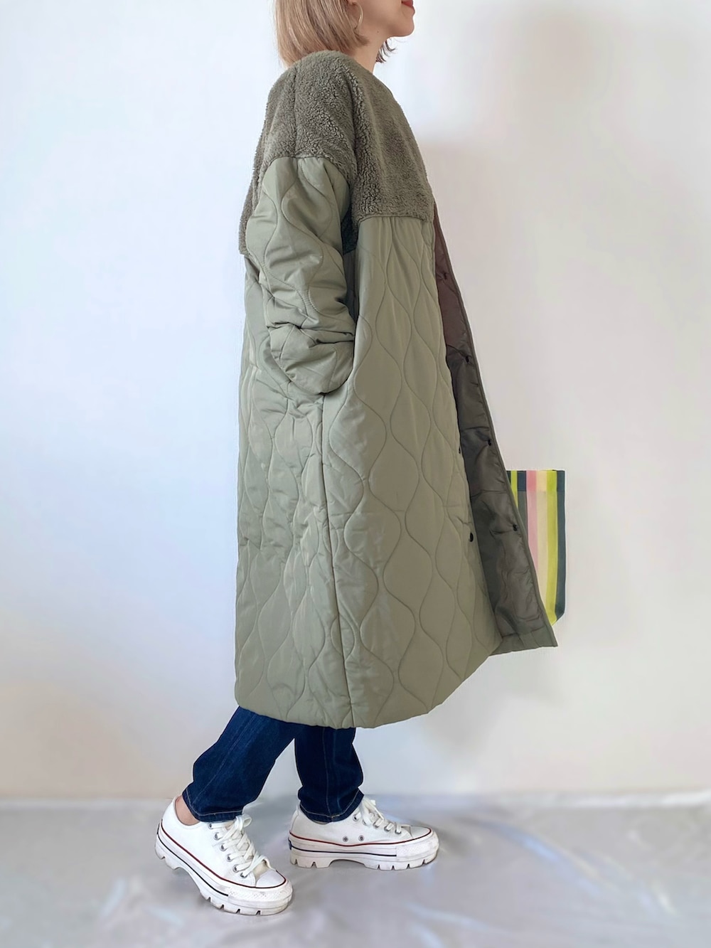 グリーン系のダウンジャケット/コート、ピンク系のニット/セーター、グリーン系のトートバッグを着用したレディースの秋コーディネートの2枚目の写真